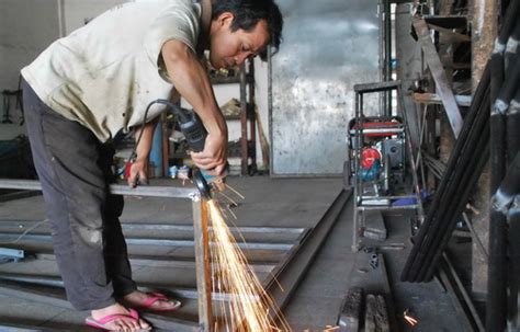 Seorang Tukang Las Membuat Pagar Dengan Cara Menyambungkan Dua Besi